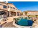 Inviting backyard pool with rock features, stone patio, and lush desert landscaping at 8219 E Tesoro Cir, Mesa, AZ 85207