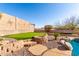 Landscaped backyard with artificial turf putting green, stone accents, and privacy wall at 8219 E Tesoro Cir, Mesa, AZ 85207