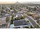 Scenic aerial view of a residential neighborhood with mature trees, pools, and mountain backdrop creating a serene and inviting atmosphere at 8409 E Clarendon Ave, Scottsdale, AZ 85251