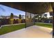 Backyard featuring a modern pergola, lush green lawn, and meticulously manicured landscaping at 8409 E Clarendon Ave, Scottsdale, AZ 85251