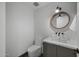 Half bathroom featuring tiled wall, modern toilet and sink with a custom mirror and lighting at 8409 E Clarendon Ave, Scottsdale, AZ 85251