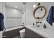 Modern bathroom features sleek fixtures, a tub with shower, and a stylish round mirror at 8409 E Clarendon Ave, Scottsdale, AZ 85251