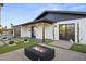 Stunning, modern home featuring a cozy front yard with desert landscaping and a striking outdoor fire pit feature at 8409 E Clarendon Ave, Scottsdale, AZ 85251
