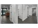 Hallway featuring white walls, gray tile flooring, and multiple storage areas at 8409 E Clarendon Ave, Scottsdale, AZ 85251