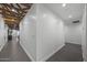 Hallway featuring exposed beam ceiling, recessed lighting, and gray tile flooring at 8409 E Clarendon Ave, Scottsdale, AZ 85251