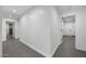 Hallway with gray tile and white walls leading to various rooms and doors at 8409 E Clarendon Ave, Scottsdale, AZ 85251