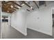 Bright hallway with exposed beams and tile flooring, leading to various rooms with fresh white walls at 8409 E Clarendon Ave, Scottsdale, AZ 85251