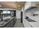 Modern kitchen featuring an island with bar seating and stainless appliances next to an open sliding glass door at 8409 E Clarendon Ave, Scottsdale, AZ 85251