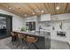 Modern kitchen boasts a large island with seating, stainless steel appliances, and stylish countertops and backsplash at 8409 E Clarendon Ave, Scottsdale, AZ 85251