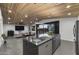 Modern kitchen with a large island, and bar seating connects to an open living space, enhancing entertainment options at 8409 E Clarendon Ave, Scottsdale, AZ 85251