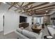 Inviting living room with exposed beams, a stylish media console, modern furniture, and a large window for natural light and comfort at 8409 E Clarendon Ave, Scottsdale, AZ 85251