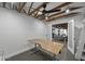 Modern office area featuring exposed beams, ceiling fan, and an open layout leading to a cozy living space at 8409 E Clarendon Ave, Scottsdale, AZ 85251