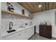 A clean, bright wet bar with shaker cabinets, white tile backsplash and floating shelf at 8409 E Clarendon Ave, Scottsdale, AZ 85251