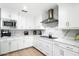 Modern all-white kitchen featuring stainless steel appliances, stone countertops, and light wood flooring at 9331 S Lakeshore Dr, Tempe, AZ 85284