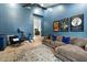 Cozy living room with blue accent wall, movie posters, plush sofa, and ceiling fan, perfect for relaxation at 9331 S Lakeshore Dr, Tempe, AZ 85284