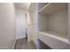 Walk-in closet featuring ample shelving and storage space, enhanced by neutral walls and wood-look tile flooring at 10411 N 11Th Ave # 28, Phoenix, AZ 85021