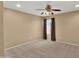 Cozy carpeted bedroom features a lighted ceiling fan and a window covered in blinds at 10656 E Plata Ave, Mesa, AZ 85212