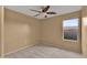 Neutral bedroom includes ceiling fan and large window at 10656 E Plata Ave, Mesa, AZ 85212