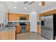 Well-lit kitchen with stainless steel appliances, wood cabinets, and tile flooring at 10656 E Plata Ave, Mesa, AZ 85212