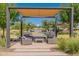 Inviting outdoor seating area with comfortable couches and tables under a shaded pergola at 11051 E Ulysses Ave, Mesa, AZ 85212