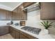 Close-up of a kitchen counter featuring dark wooden cabinets, white backsplash, and stainless steel appliances at 11051 E Ulysses Ave, Mesa, AZ 85212