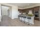 Modern kitchen featuring an island with bar stool seating, wooden cabinets, and stainless steel appliances at 11051 E Ulysses Ave, Mesa, AZ 85212