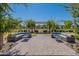 An outdoor seating area with sofas and tables is set on a paved patio framed by trees and landscaping at 11107 E Ulysses Ave, Mesa, AZ 85212