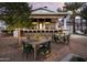 Exterior view of an outdoor bar area featuring tables and chairs, an outdoor bar, and palm trees at 11300 N Casa Dega Dr # 1000, Surprise, AZ 85388