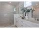 Modern bathroom featuring a glass-enclosed shower, double vanity with marble countertops, and stylish fixtures at 11300 N Casa Dega Dr # 1058, Surprise, AZ 85388