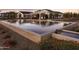 Reflective pool showing luxurious white buildings with elegant design and landscaping, under a colorful sky at 11300 N Casa Dega Dr # 1069, Surprise, AZ 85388