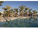 Resort-style pool area with palm trees, cabanas and clear blue water reflecting the architecture at 11300 N Casa Dega Dr # 1069, Surprise, AZ 85388