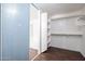 Walk-in closet featuring wood-look floors, built-in shelving and access to the bathroom at 1202 W Central Ave, Coolidge, AZ 85128