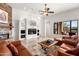 Bright living room features stone fireplace, media center, and large window overlooking the yard at 12083 E Wethersfield Dr, Scottsdale, AZ 85259