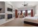 Spacious main bedroom featuring a fireplace, tray ceiling, and access to the patio at 12083 E Wethersfield Dr, Scottsdale, AZ 85259