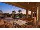 Covered patio with outdoor seating, a stone fireplace, and scenic views of the pool at 12083 E Wethersfield Dr, Scottsdale, AZ 85259