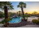 Tranquil pool and waterfall feature surrounded by mature palm trees at 12083 E Wethersfield Dr, Scottsdale, AZ 85259