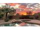 Gorgeous sunset reflecting in the pool water surrounded by lush landscaping at 12083 E Wethersfield Dr, Scottsdale, AZ 85259