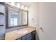 Bathroom features a granite vanity, large framed mirror, and a view to the patio outside of a nearby bedroom at 1222 W Baseline Rd # 116, Tempe, AZ 85283