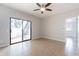 An empty bedroom features light walls, a ceiling fan, tile floors, and a sliding glass door leading outside at 1222 W Baseline Rd # 116, Tempe, AZ 85283