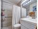 The bathroom features neutral tiling, safety bars in the shower, and a well-lit vanity with a sleek, modern sink at 1340 E Townley Ave, Phoenix, AZ 85020