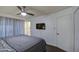 The bedroom features neutral colors, a modern ceiling fan, and a view of an ensuite bath at 1340 E Townley Ave, Phoenix, AZ 85020