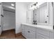 Modern bathroom featuring white cabinets, countertop, black fixtures, and a large mirror at 13677 N 108Th Dr, Sun City, AZ 85351