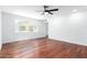 Bright bedroom features wood floors, a ceiling fan, neutral walls, and a large window at 13677 N 108Th Dr, Sun City, AZ 85351