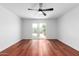 Bright bedroom featuring hardwood floors, ceiling fan, and sliding glass door to the backyard at 13677 N 108Th Dr, Sun City, AZ 85351