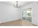 Dining area with modern chandelier, tile flooring, and a sliding glass door to backyard at 13677 N 108Th Dr, Sun City, AZ 85351