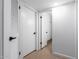 Hallway featuring tile flooring, multiple white doors, and ample lighting at 13677 N 108Th Dr, Sun City, AZ 85351