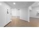 Open hallway with white walls, wood-look tile floors and an open-concept view into the kitchen and living spaces at 13677 N 108Th Dr, Sun City, AZ 85351