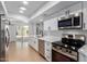 A modern kitchen featuring stainless steel appliances, white cabinets, quartz countertops, and an outdoor patio view at 13677 N 108Th Dr, Sun City, AZ 85351