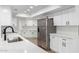 Modern kitchen featuring white cabinetry, a stainless steel refrigerator, and quartz countertops at 13677 N 108Th Dr, Sun City, AZ 85351