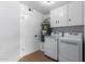 Functional laundry room with modern washer and dryer, ample counter space, and clean aesthetic at 13677 N 108Th Dr, Sun City, AZ 85351